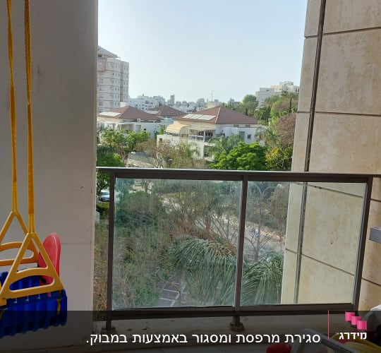 נדנדה תלויה בצבעים כחול וצהוב במרפסת